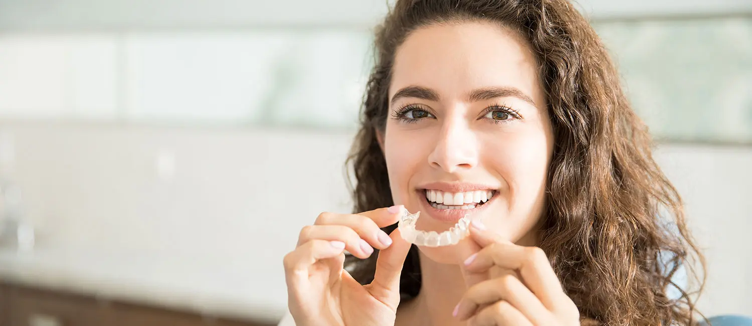 Zahnschienen-München-Zahnkonzept-Aying Zahnschienen München - Frau hält Zahnschiene zum Einsetzten