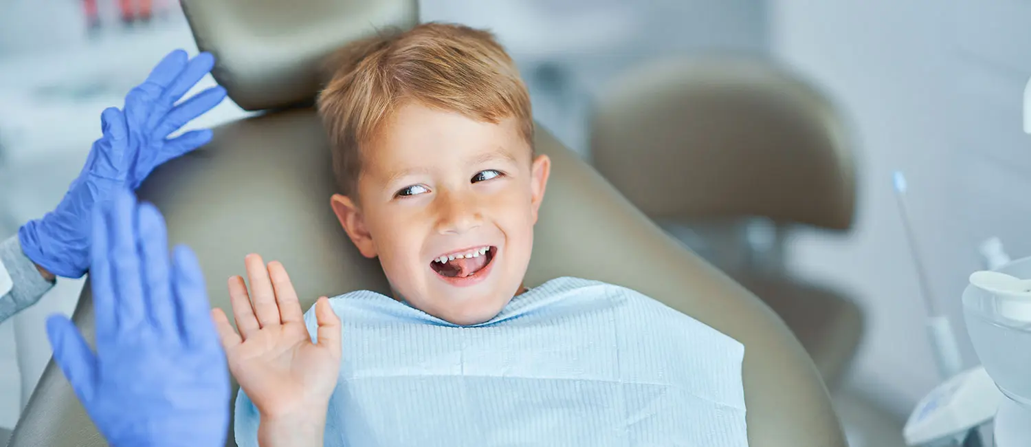 Kinderzahnarzt-Taufkirchen-Junge-Zahnarztstuhl Kinderzahnarzt Taufkirchen - Junge sitzt auf dem Zahnarztstuhl